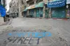 Welcome to Apartheid Street painted on the road on Shuhada Street in Hebron