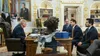 Trump at the Resolute desk facing Eduardo and Flávio Bolsonaro and Paulo Figueiredo seated across from him in the Oval Office