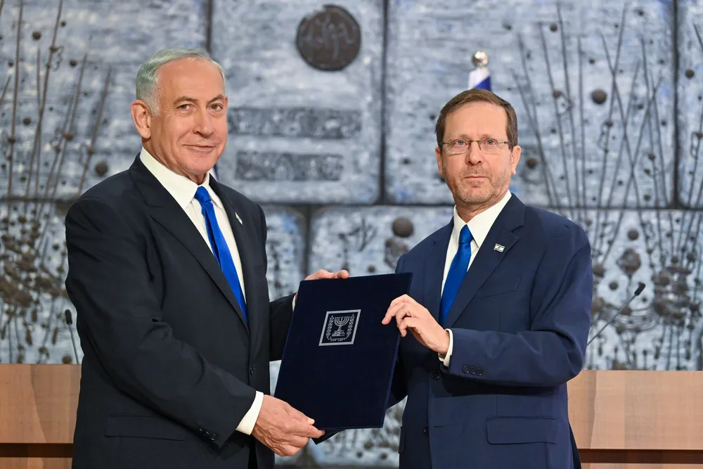 President Isaac Herzog hands Benjamin Netanyahu the letter tasking him with forming a government