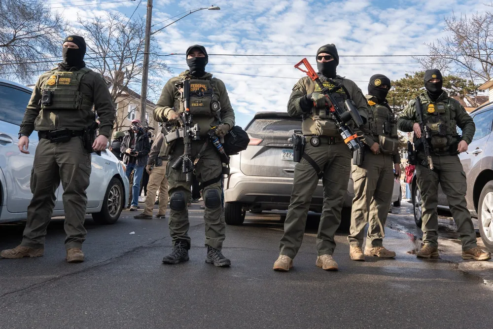 Masked, armed federal agents standing in a street in Minneapolis