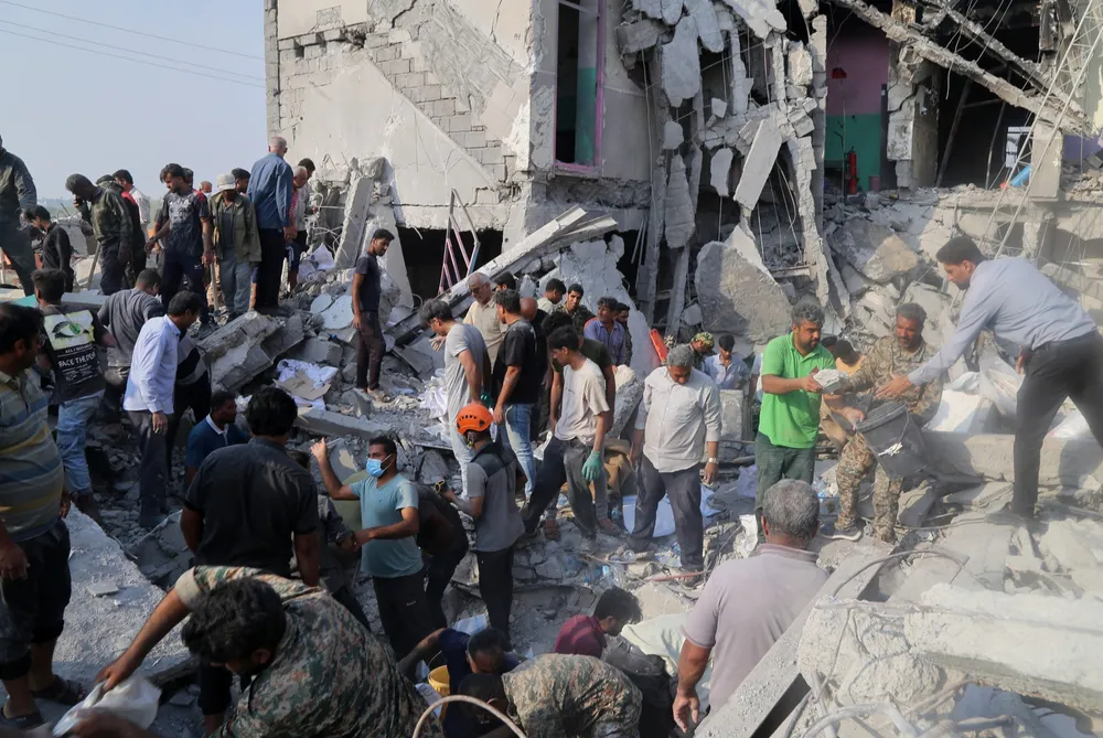 Rescuers and residents dig through the rubble of the Shajareh Tayyebeh elementary school in Minab, Iran, after the U.S. strike on 28 February 2026