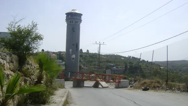 A closed Israeli gate and watchtower on the road into Beit Ommar