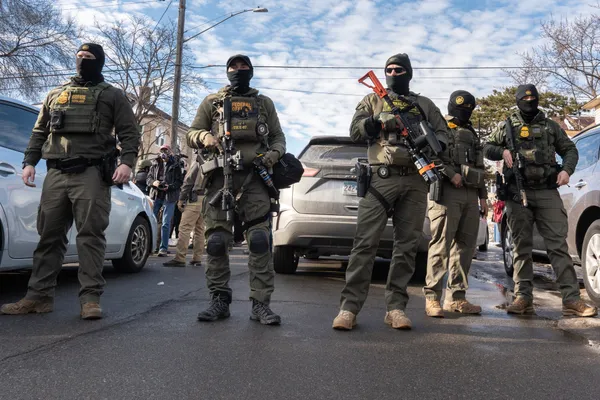 Masked, armed federal agents standing in a street in Minneapolis