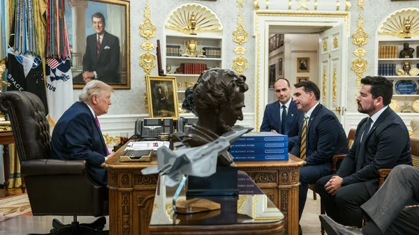 Trump at the Resolute desk facing Eduardo and Flávio Bolsonaro and Paulo Figueiredo seated across from him in the Oval Office